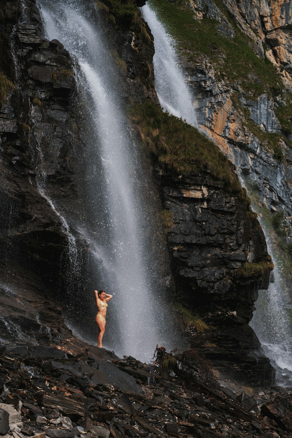 a woman standing in front of a waterfall