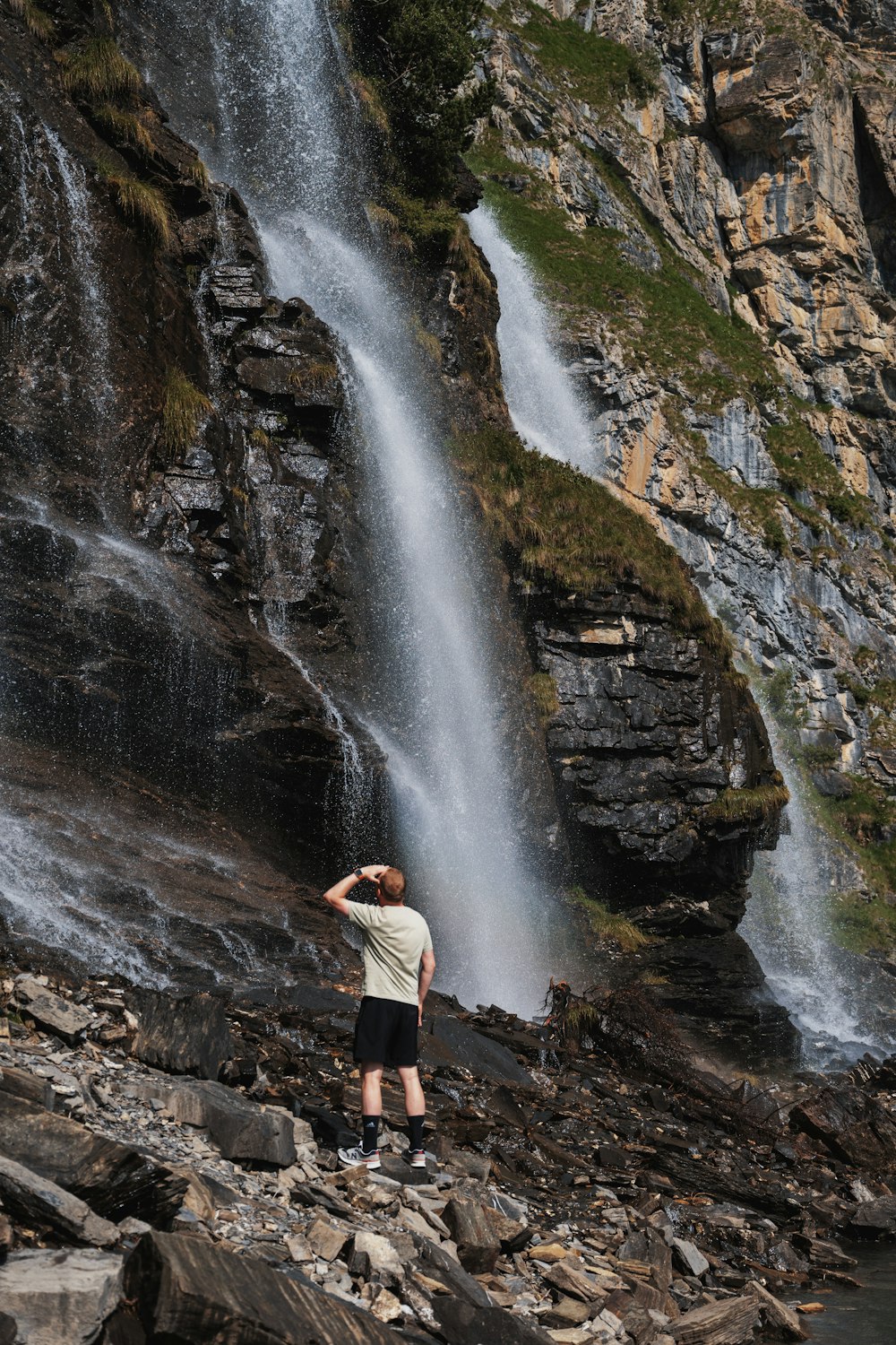 a man standing in front of a waterfall