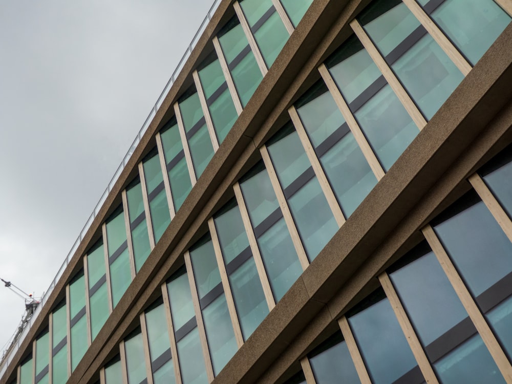 a tall building with lots of windows next to a crane