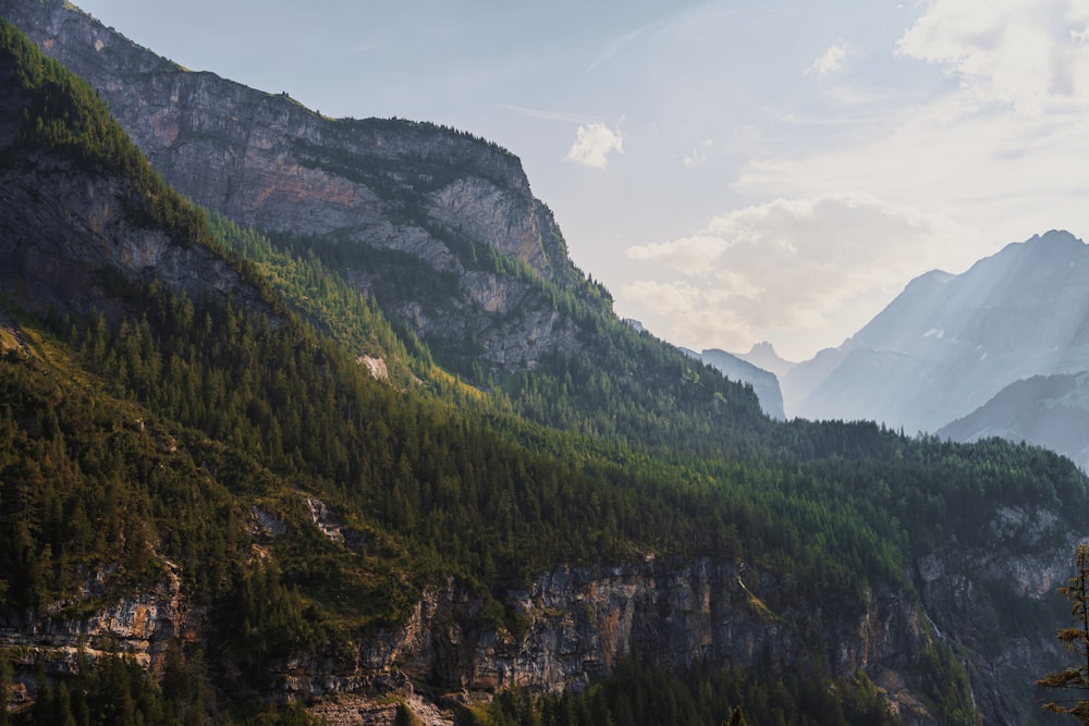 a view of a mountain range with trees and mountains in the background