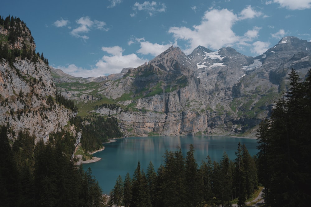 a mountain range with a lake surrounded by trees