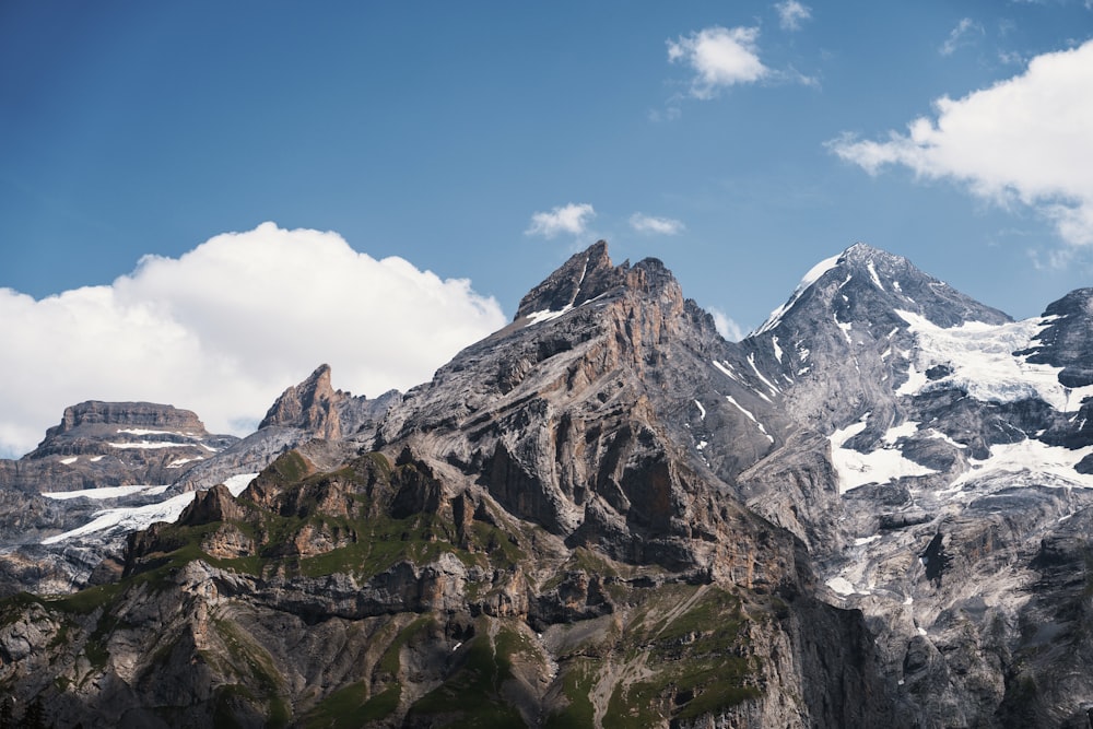 a mountain range covered in snow under a blue sky