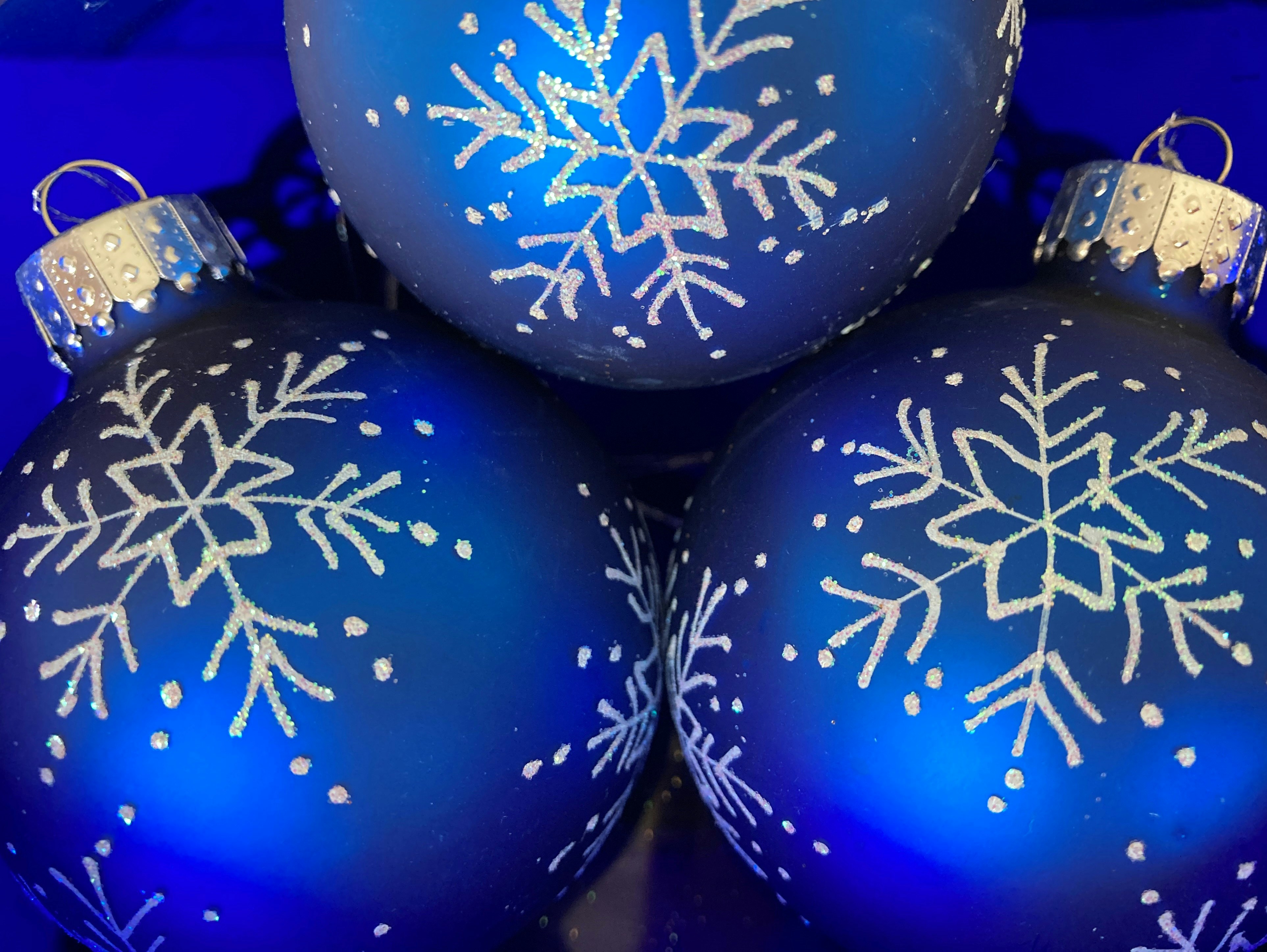 blue christmas ornaments with white snowflakes on them