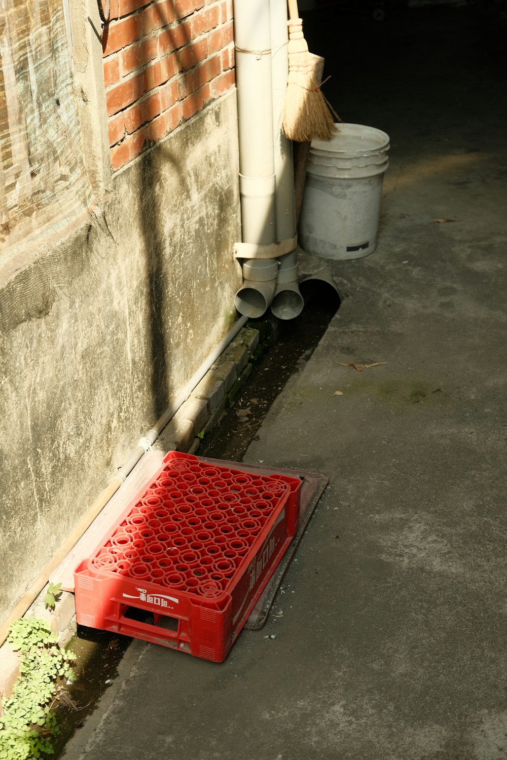 a red crate sitting on the side of a building