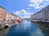 A vibrant canal lined with colorful houseboats under a clear blue sky.