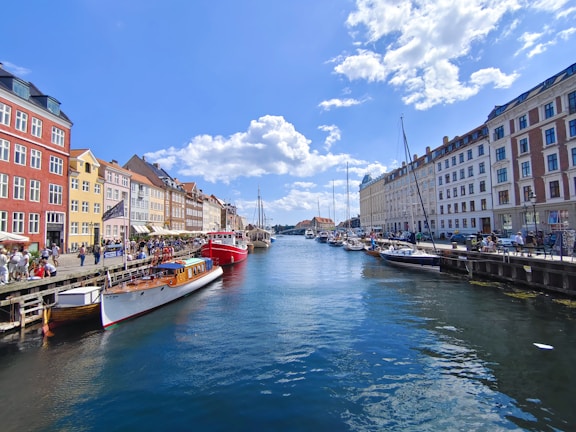 A vibrant canal lined with colorful houseboats under a clear blue sky.