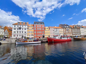 A vibrant waterfront scene in Portuguesa, Venezuela, showcasing local boats and colorful buildings under a clear blue sky.