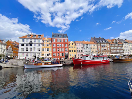 A vibrant waterfront scene in Portuguesa, Venezuela, showcasing local boats and colorful buildings under a clear blue sky.