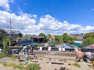 A friendly social worker speaking with diverse community members in a sunny Frankfurt park.