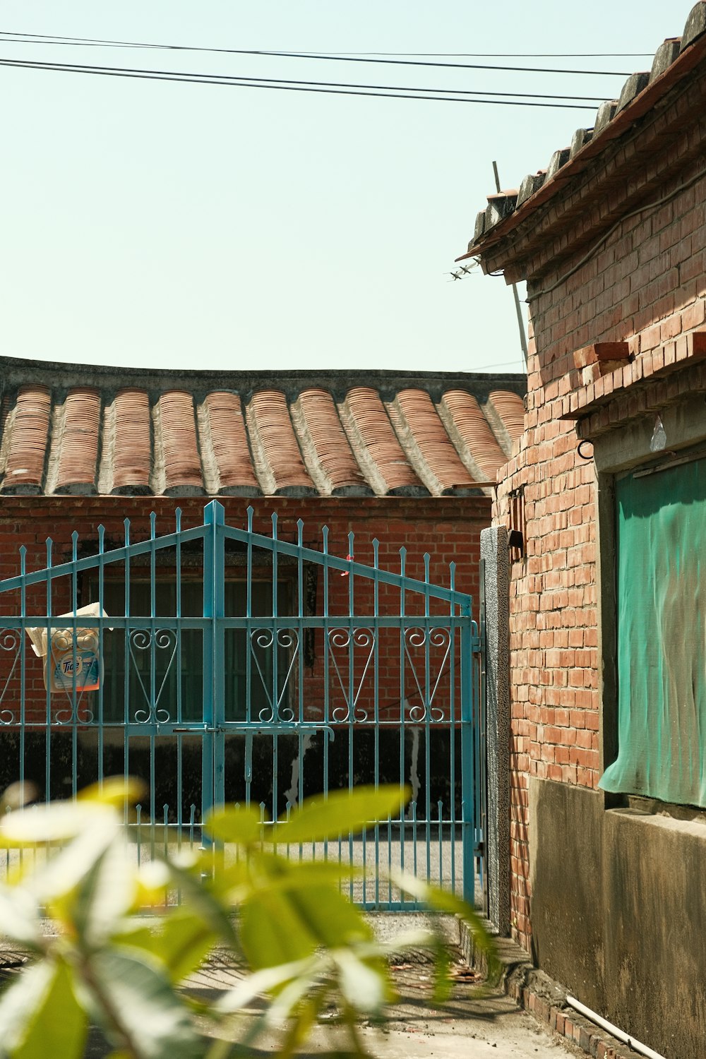 a brick building with a blue gate in front of it