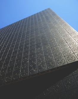 Modern building exterior featuring layered metal façade panels creating depth and shadow.
