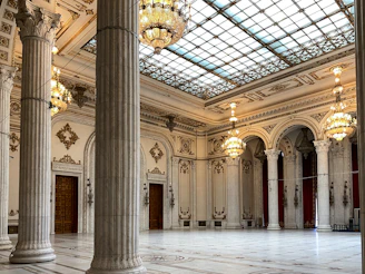 a large room with columns and chandeliers