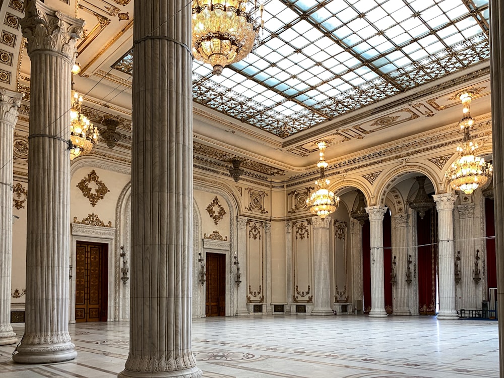 a large room with columns and chandeliers