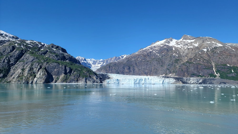 a large glacier with mountains in the background