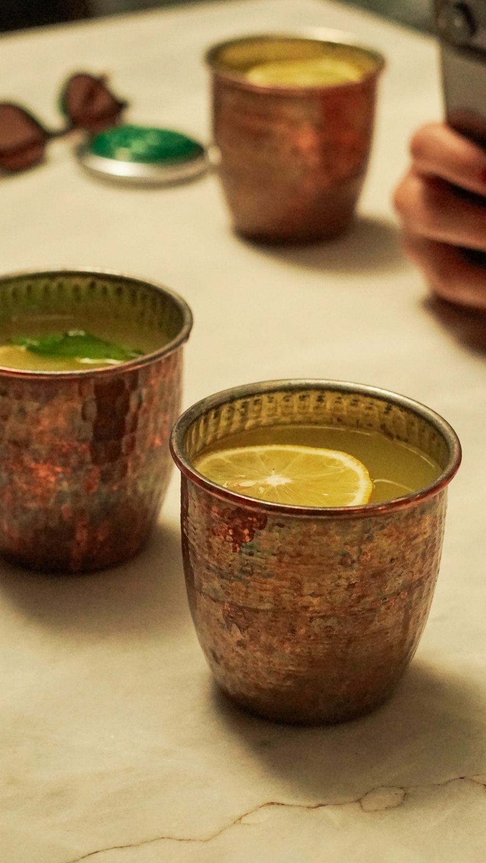 a table topped with two cups filled with liquid