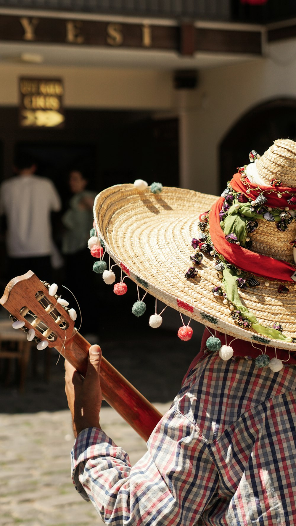 a man in a straw hat playing a guitar