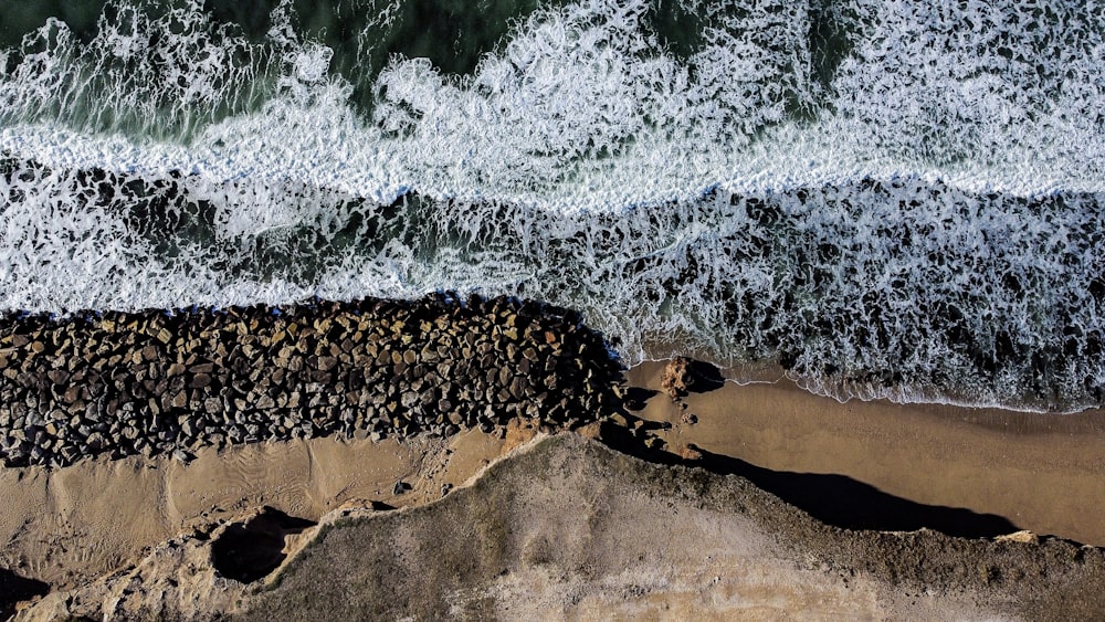 uma vista aérea de uma praia com ondas batendo nela