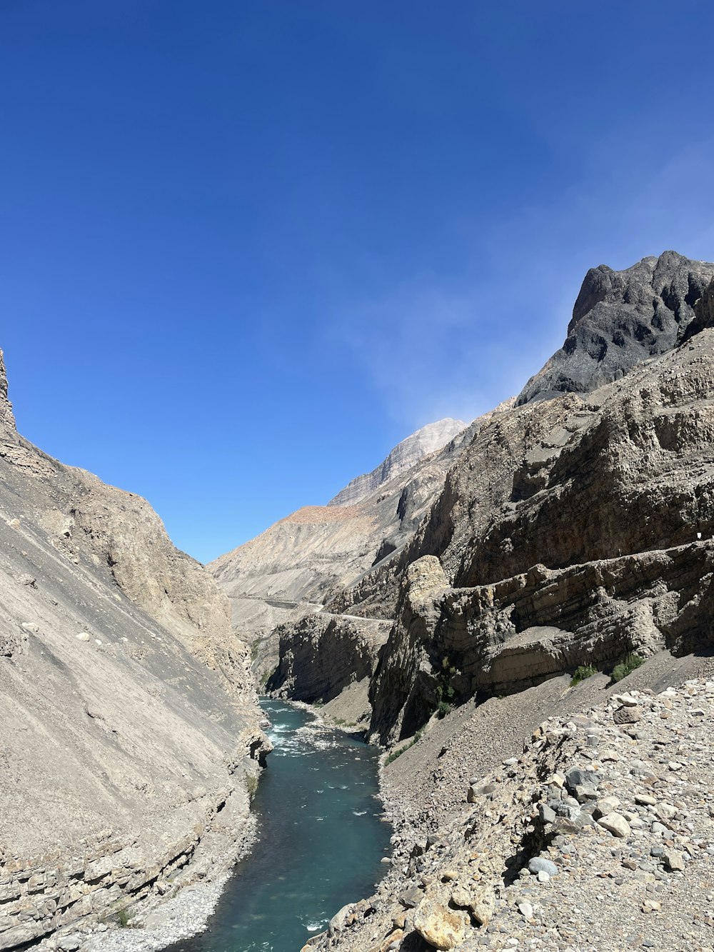 a river running through a valley surrounded by mountains