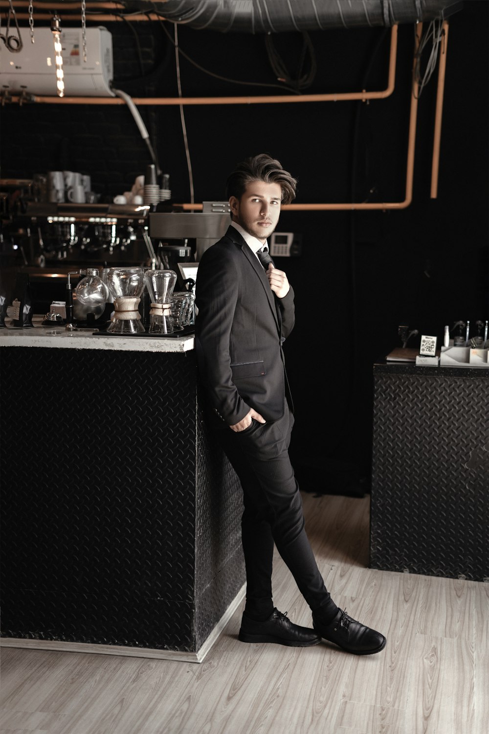 a man in a suit standing in front of a counter