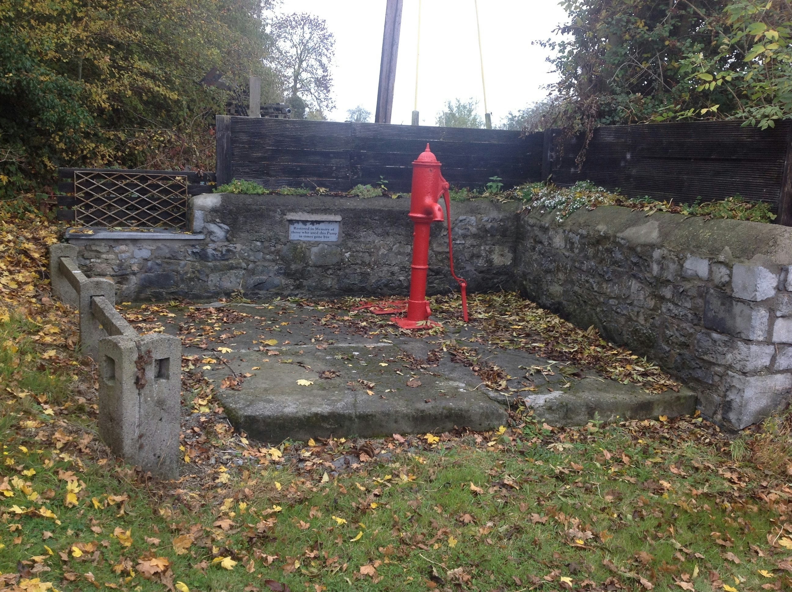 a red fire hydrant sitting next to a stone wall