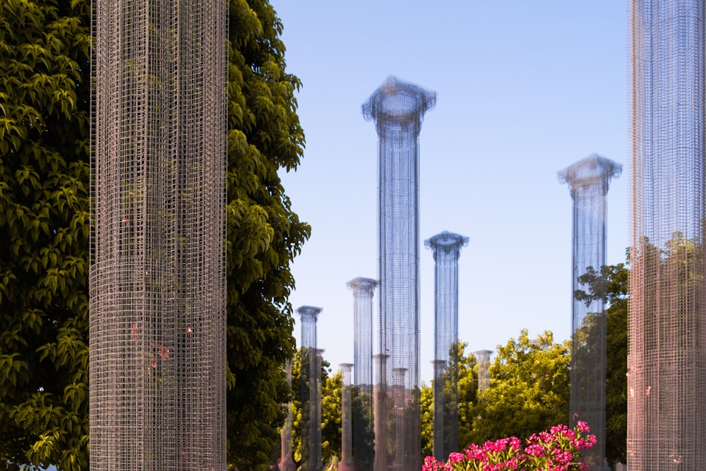 a group of tall metal poles sitting next to a lush green park