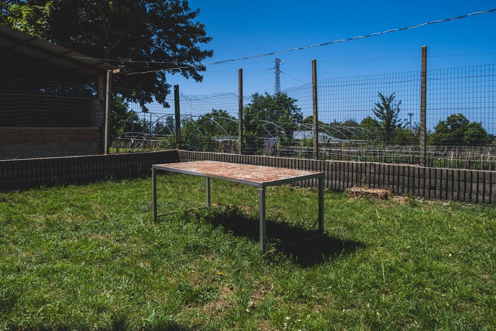 a wooden table sitting on top of a lush green field