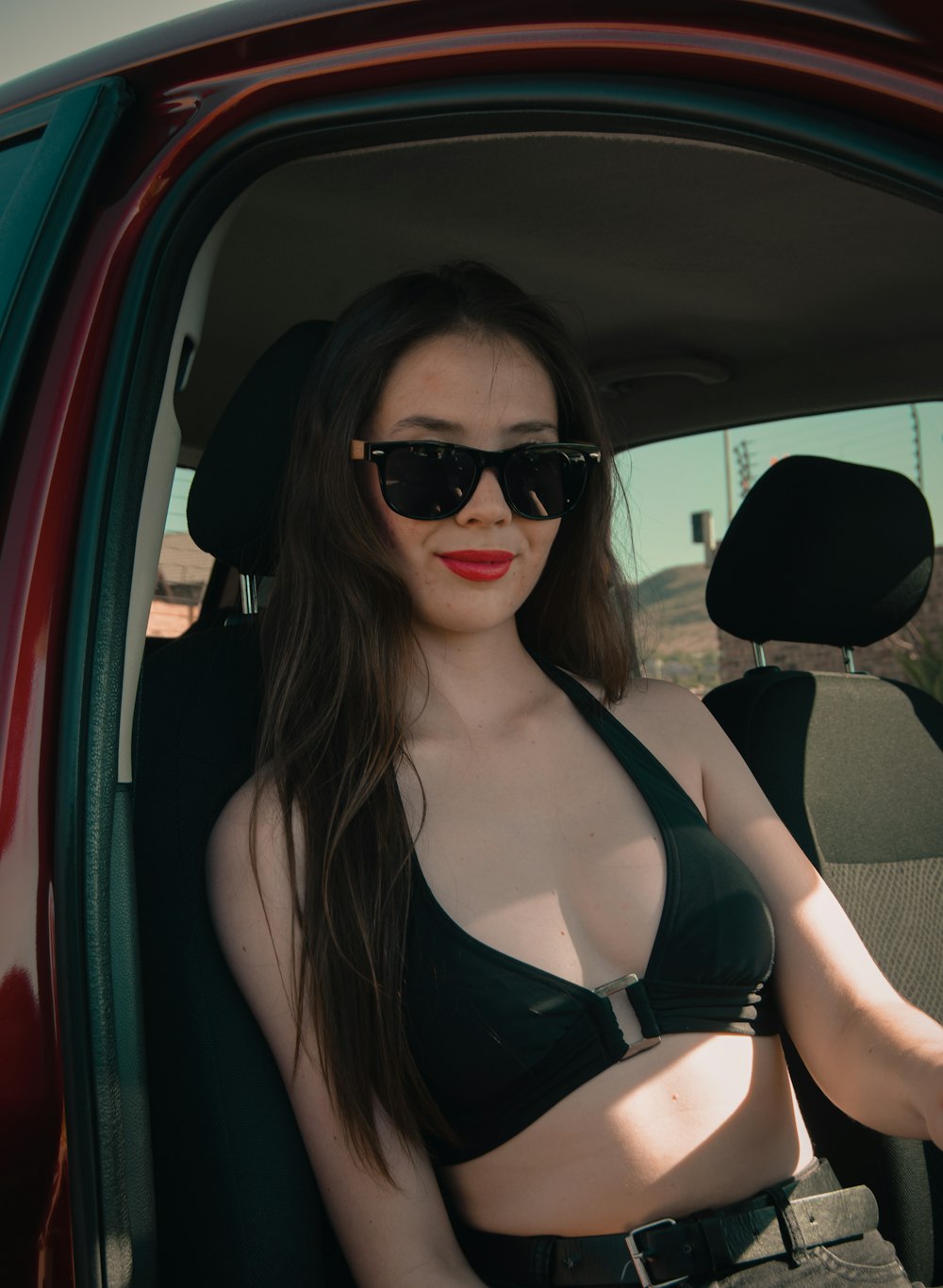 a woman in a bikini sitting in a car