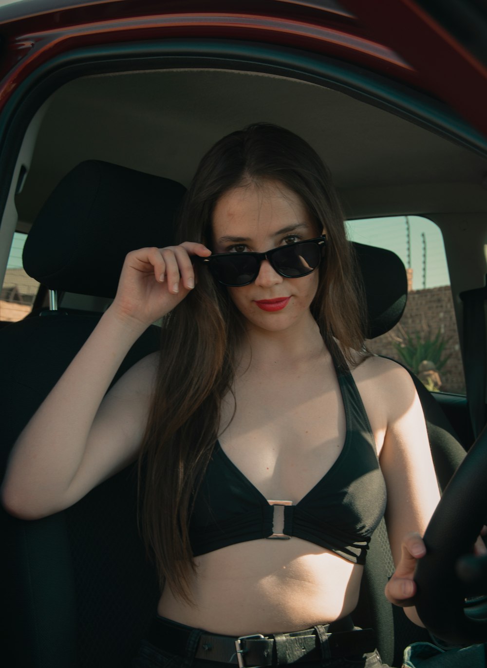 a woman in a bikini sitting in a car