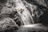 Person descending a waterfall during a canyoning adventure in Cantabria.