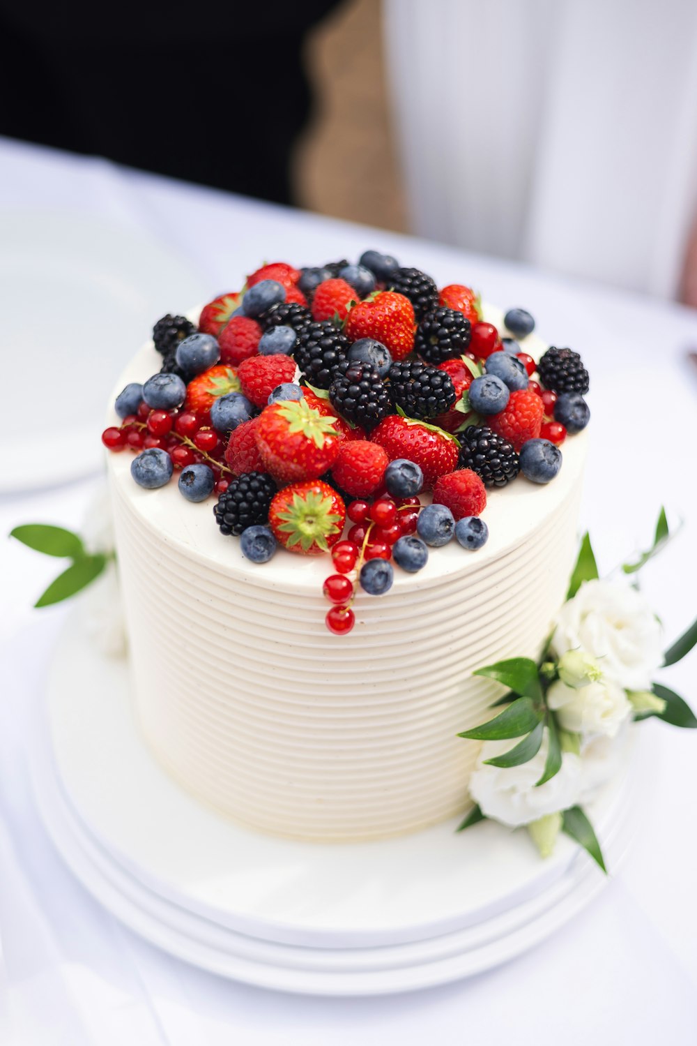 una torta bianca condita con frutti di bosco e mirtilli
