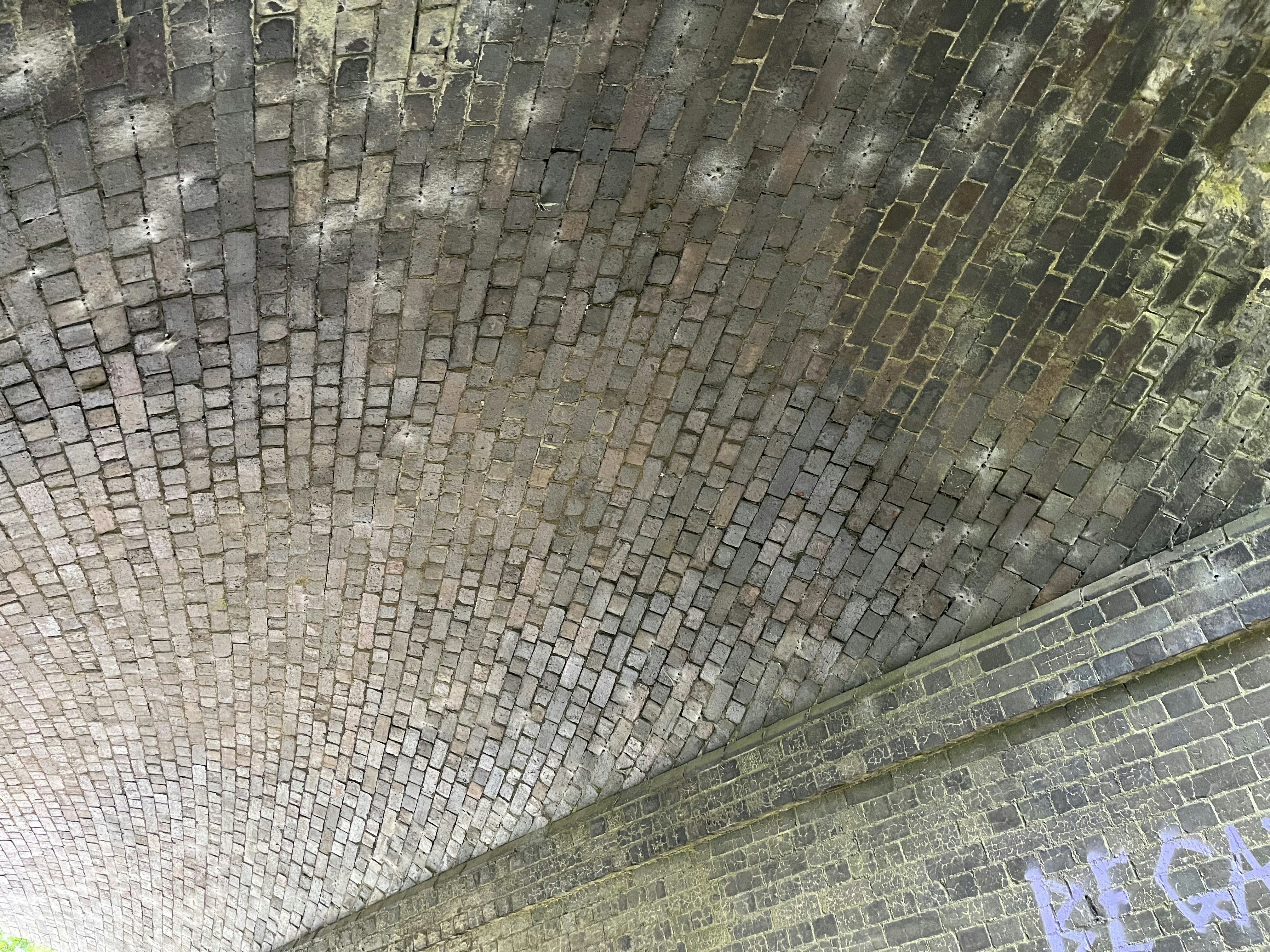 a stop sign on the side of a brick wall