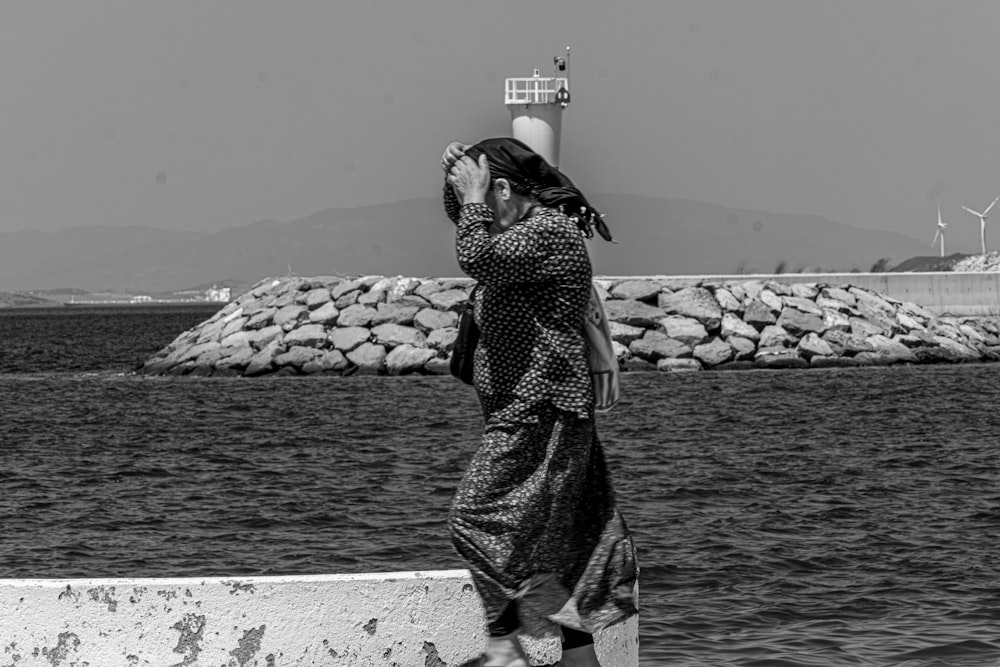 a woman in a long dress standing on a pier