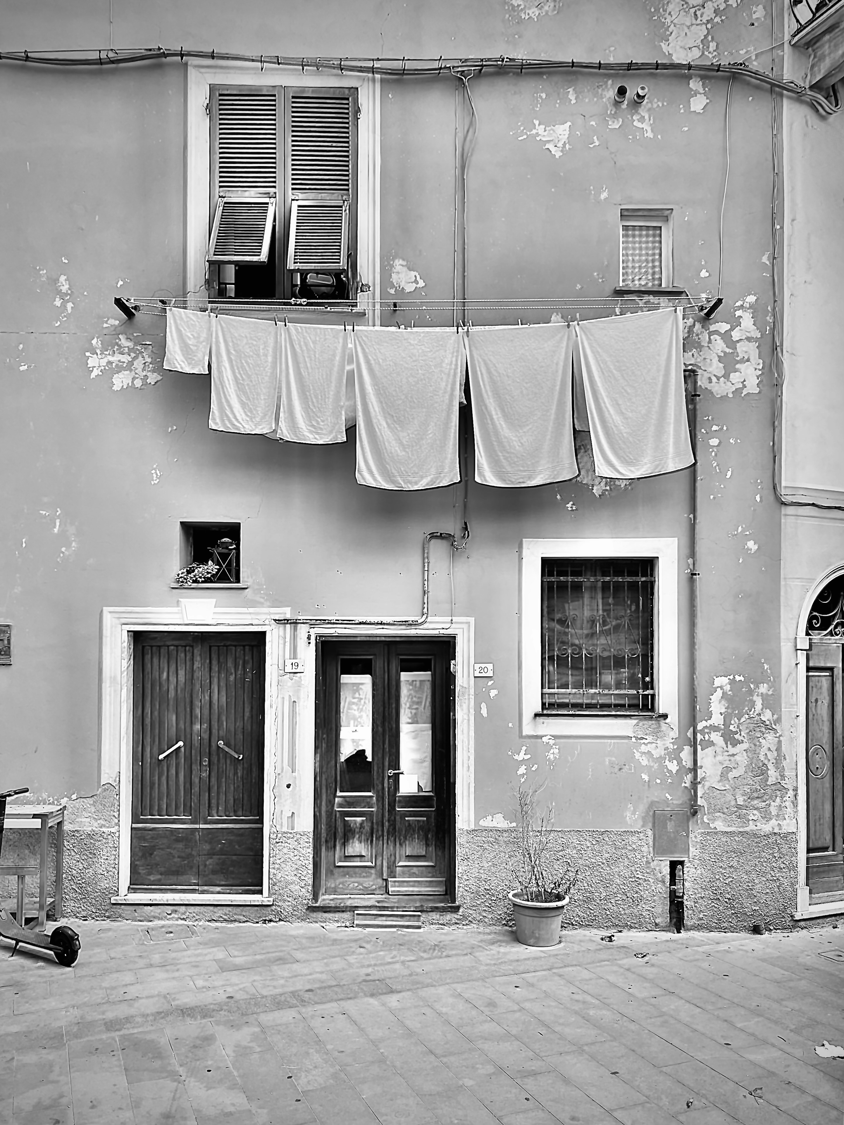 a black and white photo of a building with clothes hanging out to dry
