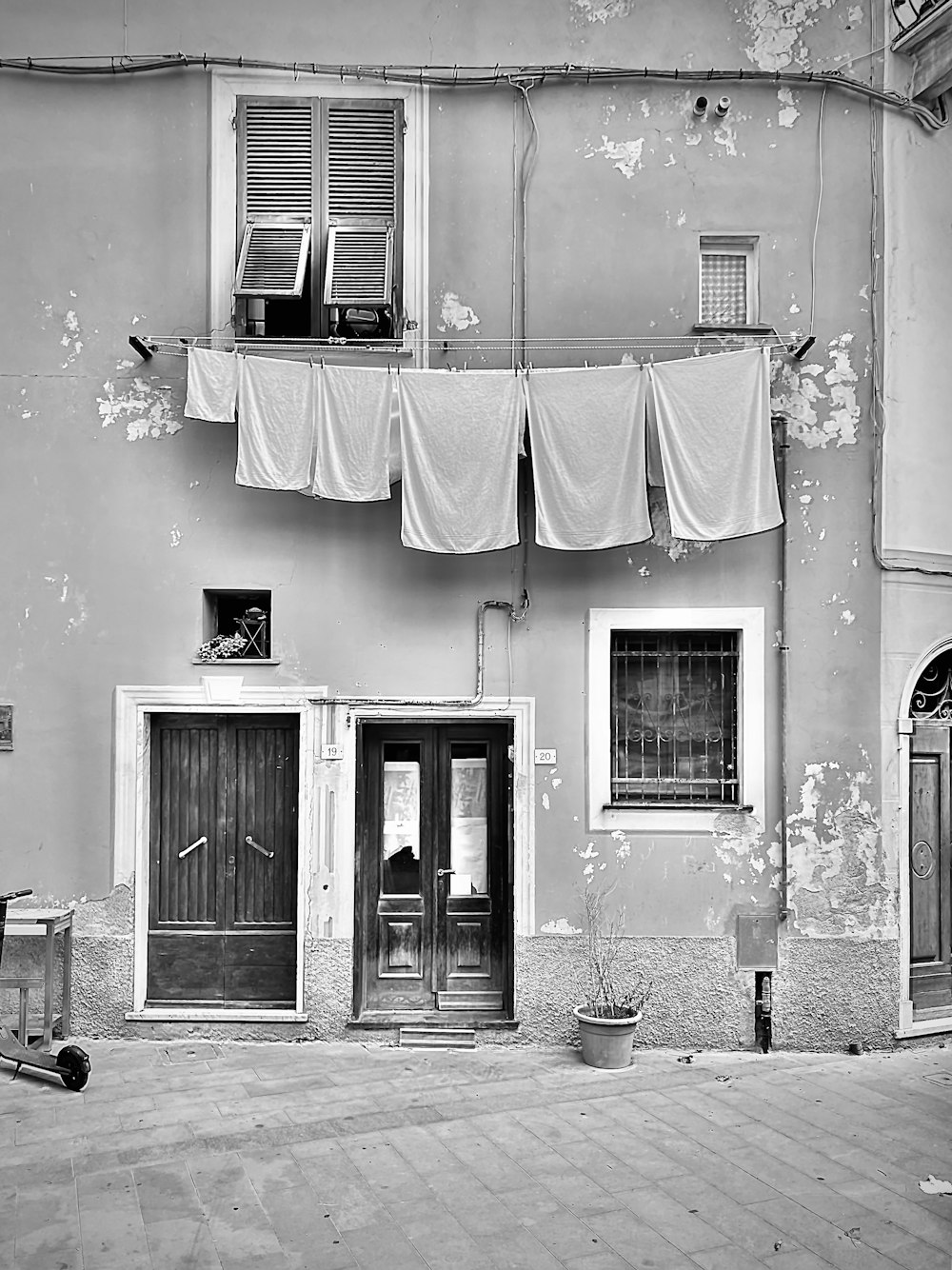 a black and white photo of a building with clothes hanging out to dry
