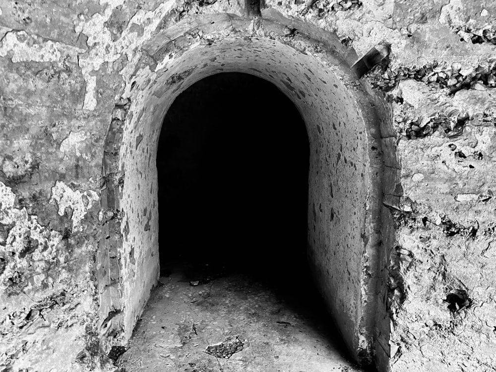 a black and white photo of a stone tunnel
