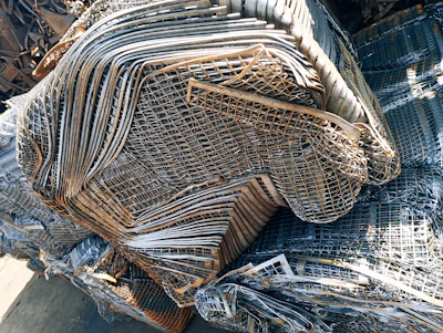 A bustling metal scrap yard with stacks of aluminium and ferrous scrap ready for processing.