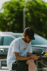 a man sitting on a bench looking at his cell phone