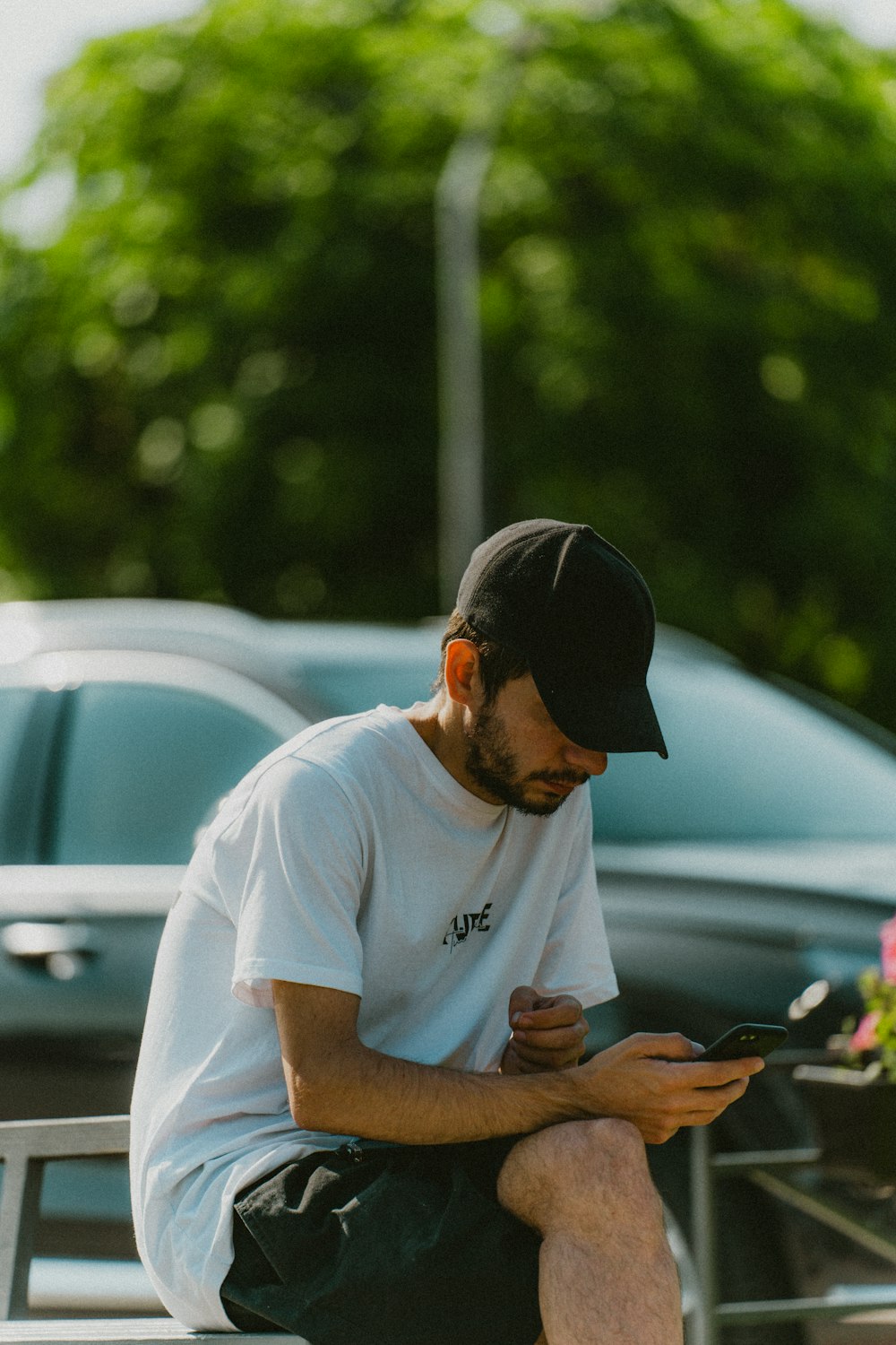 a man sitting on a bench looking at his cell phone