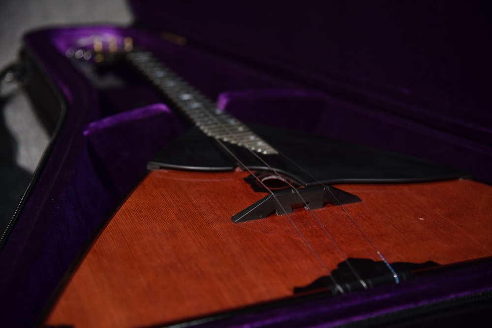a guitar in a purple case on a table