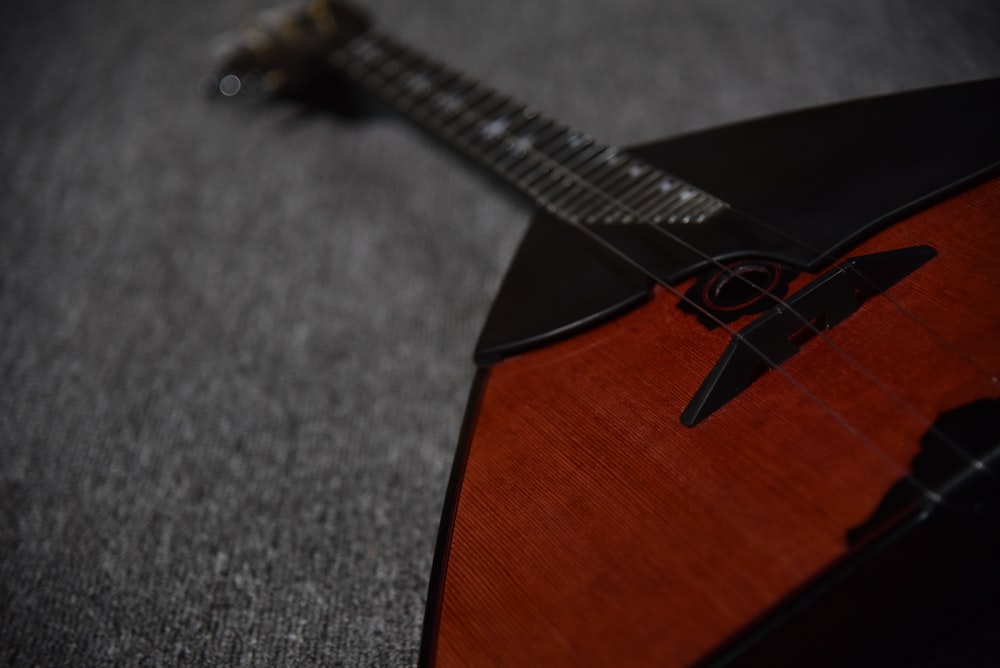 um close up de uma guitarra em uma superfície cinza