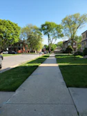 A wide shot of a newly completed sidewalk winding through a suburban neighborhood.