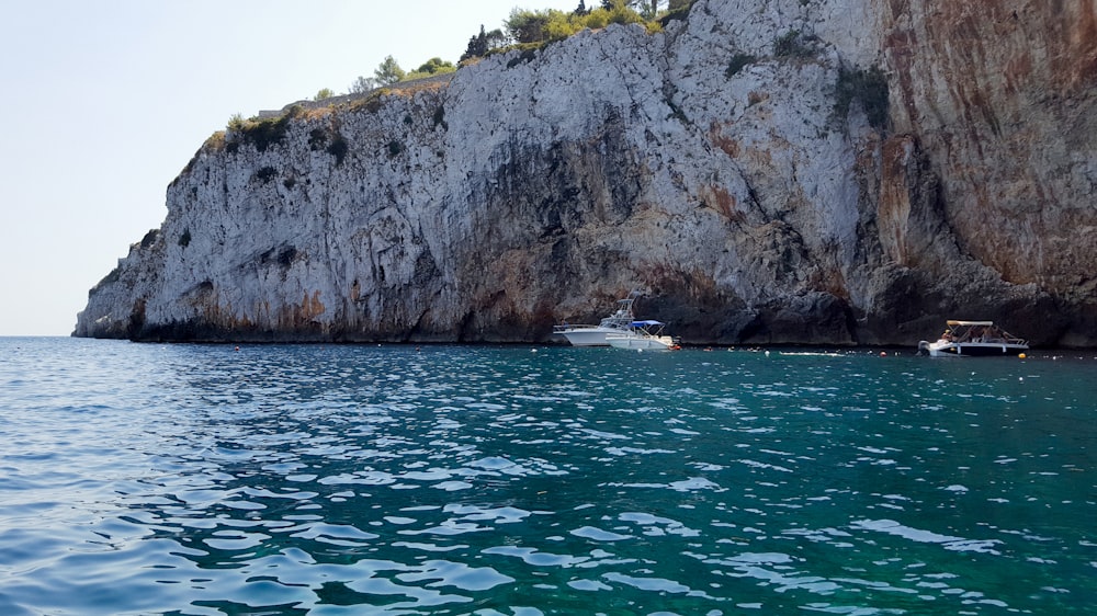 a boat in a body of water near a cliff