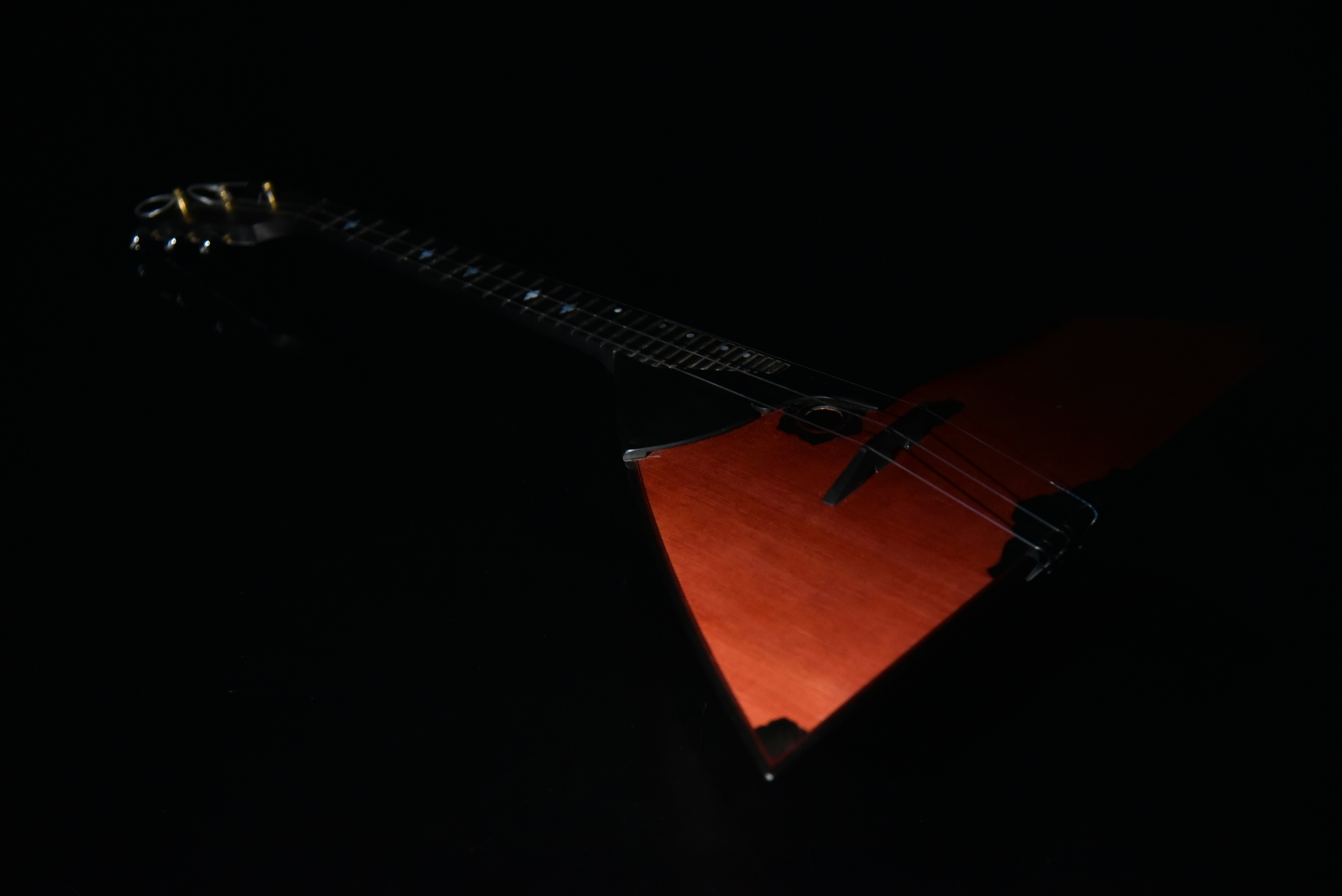 a red guitar sitting on top of a black table