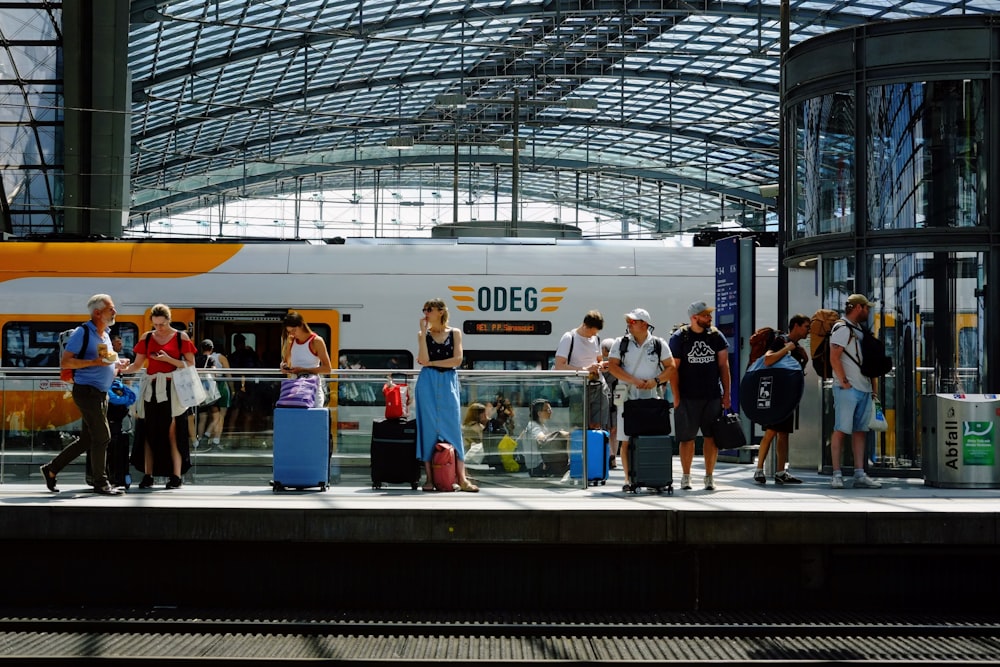 a group of people standing on a platform next to a train