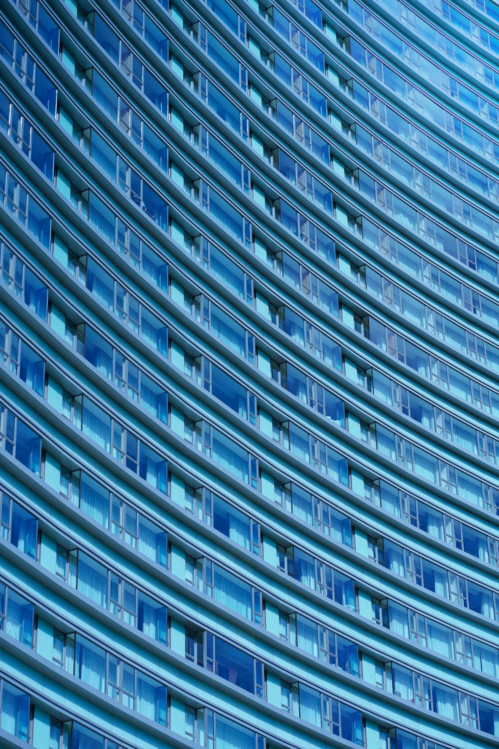 A sleek glass facade reflecting a vibrant cityscape, showcasing the precision and clarity of Shree Chamunda's craftsmanship.