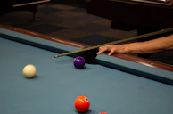 Close-up of a classic wooden pool table corner with detailed craftsmanship.