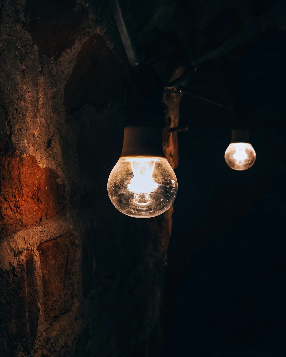 a light bulb hanging from a brick wall