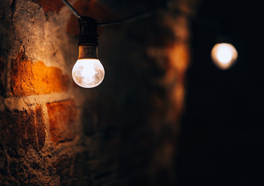 a light bulb hanging from a brick wall