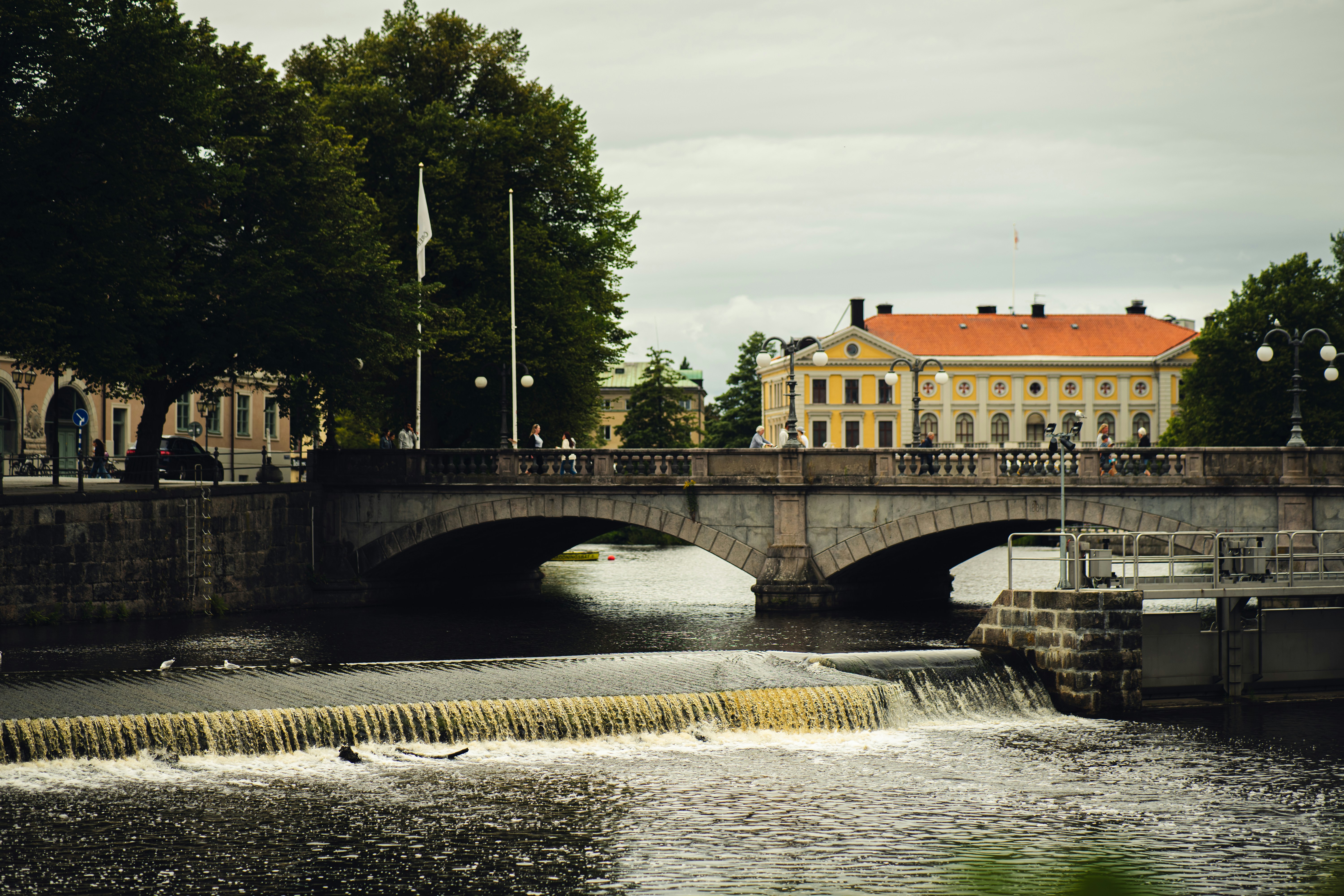 a bridge over a body of water with a building in the background