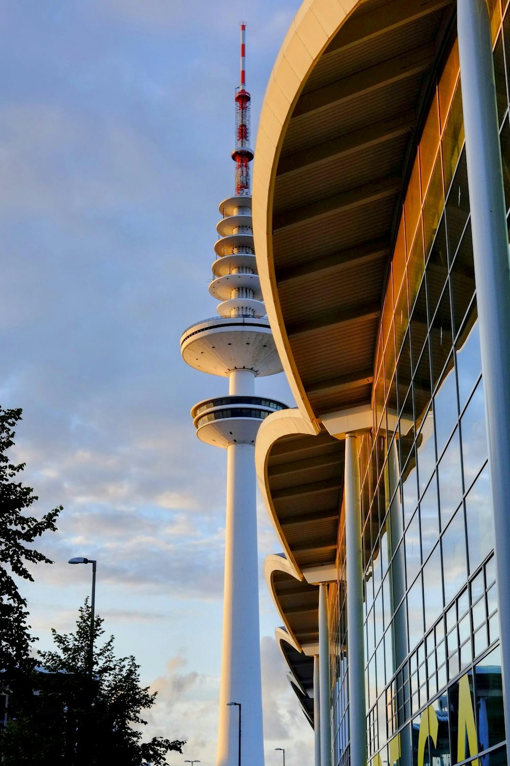 a tall building with a red and white tower next to it